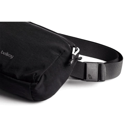 A black bum bag with a textured fabric surface and an adjustable strap, featuring a logo on the side.