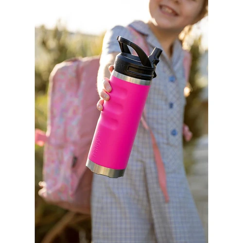 Lifestyle image of a child holding a vibrant pink fridgy® 540ml insulated water bottle with a flip-up straw lid, ergonomic grip contours, and a stainless steel base, alongside a backpack outdoors.