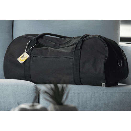 A black duffel bag rests on a light blue couch, featuring a zipper pocket and a tag. A black duffel bag rests on a light blue couch, featuring a zipper pocket and a tag.