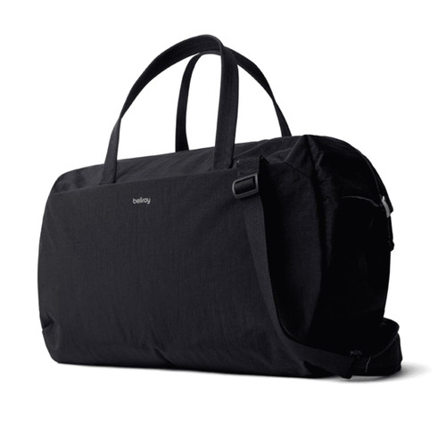A black duffel bag with two handles and a shoulder strap, featuring a logo. A black duffel bag with two handles and a shoulder strap, featuring a logo.