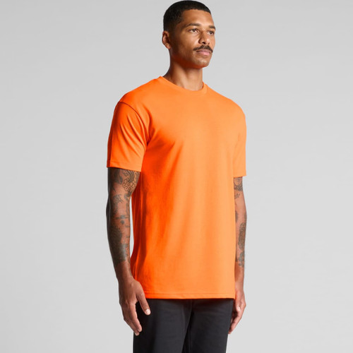An orange work t-shirt featuring a crew neck and logoed branding, shown on a model with tattoos. An orange work t-shirt featuring a crew neck and logoed branding, shown on a model with tattoos.