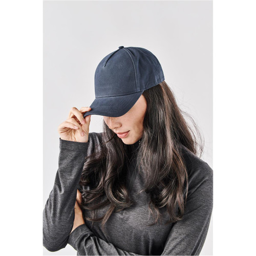 A navy Explorer Cap displayed on a model with long hair, featuring a simple design and a logo.