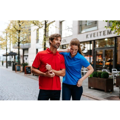 A red polo shirt and a blue polo shirt displayed on a couple walking through an urban street. Both shirts have logos.