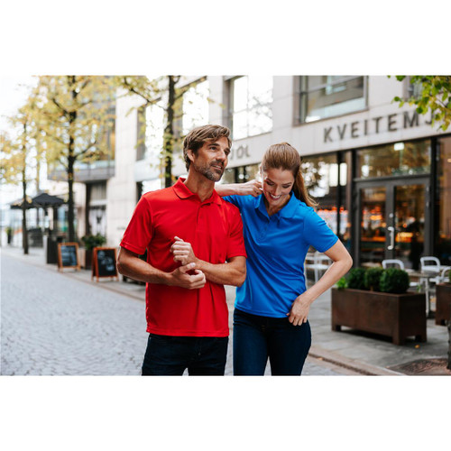 A red and blue men's polo shirt displayed on models in an outdoor urban setting with shop fronts in the background.