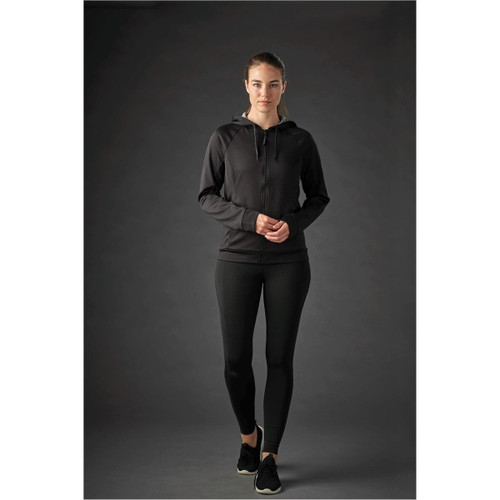 A womenās black Halifax hoody with a zip and hood, paired with black leggings, displayed on a model. A womenās black Halifax hoody with a zip and hood, paired with black leggings, displayed on a model.