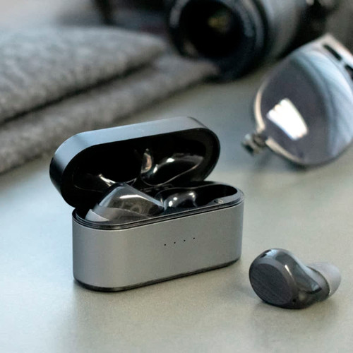 Wireless earbuds in a grey charging case, with one earbud outside the case, set on a flat surface.