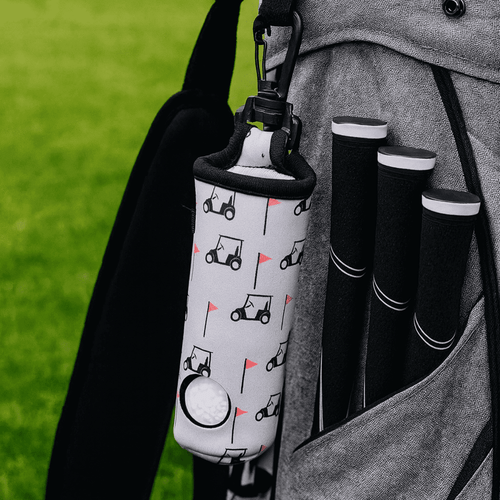 A neoprene golf ball sleeve with a golf cart design, attached to a grey golf bag alongside black golf club grips. A neoprene golf ball sleeve with a golf cart design, attached to a grey golf bag alongside black golf club grips.