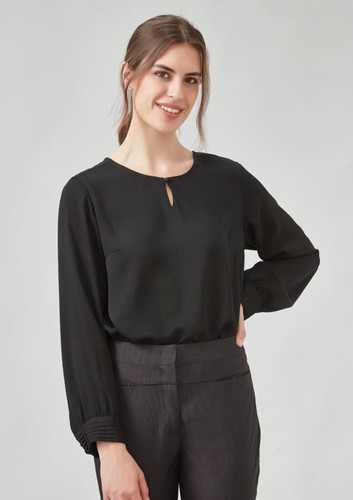 A black long sleeve blouse with a keyhole neckline, styled with grey trousers. The model has a neutral expression. A black long sleeve blouse with a keyhole neckline, styled with grey trousers. The model has a neutral expression.