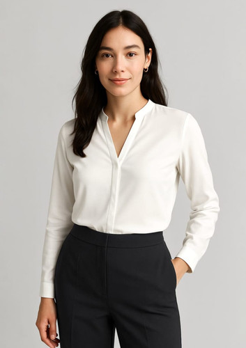 A white long sleeve blouse with a collar, worn by a woman, paired with dark trousers. Branding is present. A white long sleeve blouse with a collar, worn by a woman, paired with dark trousers. Branding is present.