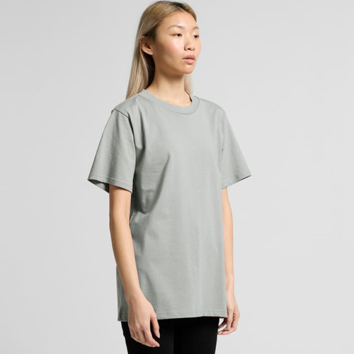 A model wearing a grey T-shirt with short sleeves and a relaxed fit, featuring a simple design.