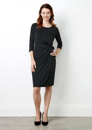 A black women's dress featuring a twist detail at the waist and three-quarter sleeves, paired with black heels. A black women's dress featuring a twist detail at the waist and three-quarter sleeves, paired with black heels.