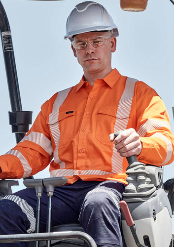 A man wearing an orange hi-vis shirt with segmented reflective tape operates machinery while wearing a white hard hat and safety glasses. A man wearing an orange hi-vis shirt with segmented reflective tape operates machinery while wearing a white hard hat and safety glasses.