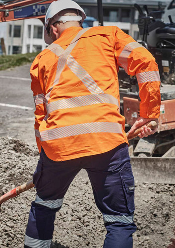 A men's hi-vis orange shirt featuring segmented reflective tape, worn with navy blue work pants. A men's hi-vis orange shirt featuring segmented reflective tape, worn with navy blue work pants.