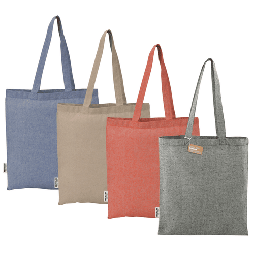 Four recycled cotton twill tote bags in blue, beige, coral, and grey, each with a branded label attached. Four recycled cotton twill tote bags in blue, beige, coral, and grey, each with a branded label attached.