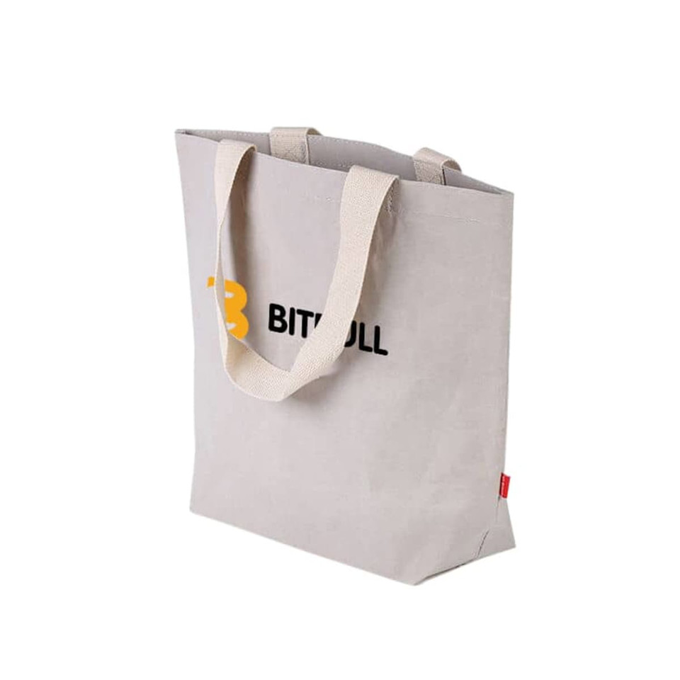 A large, grey washable kraft paper bag with cotton handles and a logo on the front.
