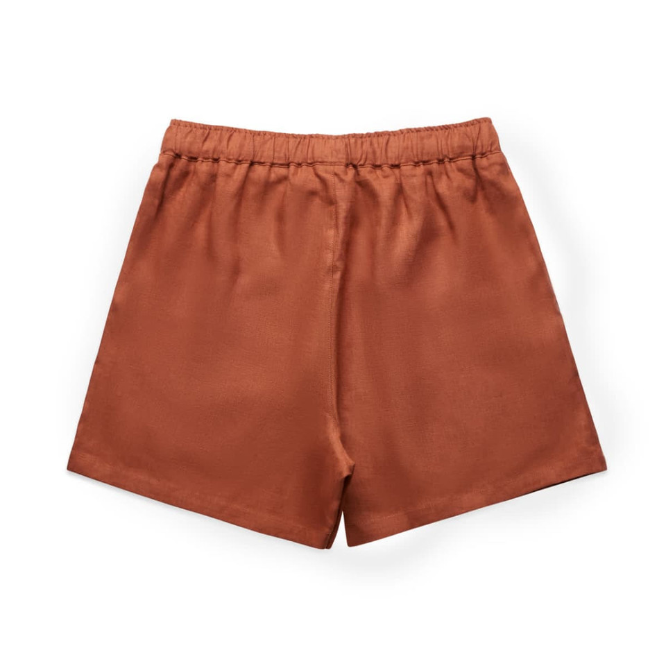 Rust-coloured linen shorts with an elastic waistband. The back view highlights a simple, smooth design.