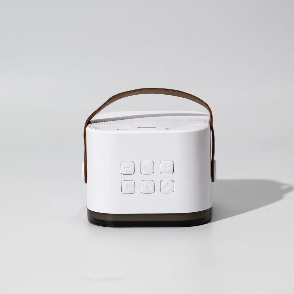 A portable karaoke machine in white and brown, featuring a handle and multiple buttons on the front.