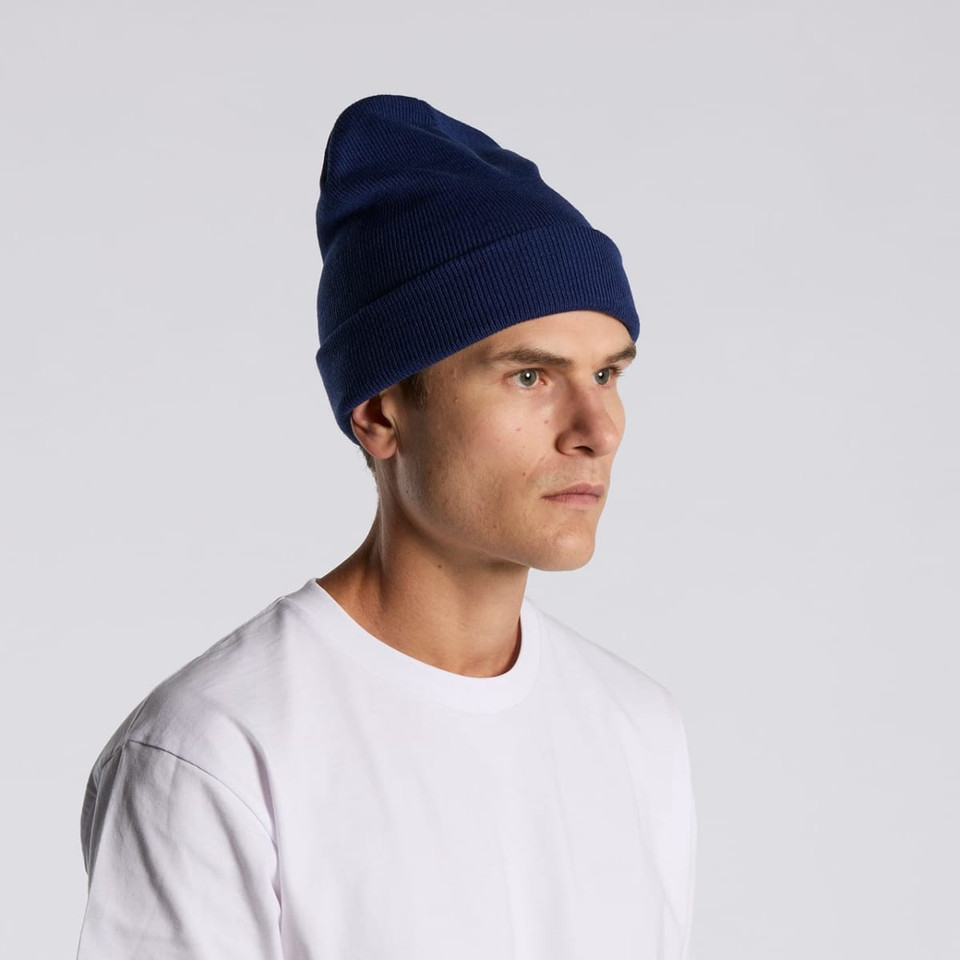 A navy blue cuff beanie displayed on a model, featuring a ribbed texture and a snug fit.