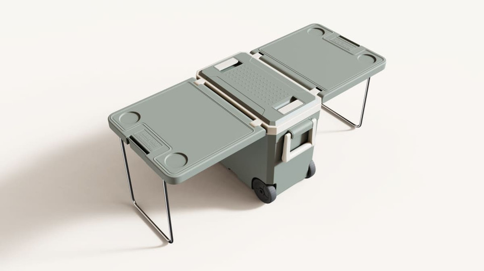 A green cooler box with folding table and chair attachments, featuring wheels and a handle for easy transport.