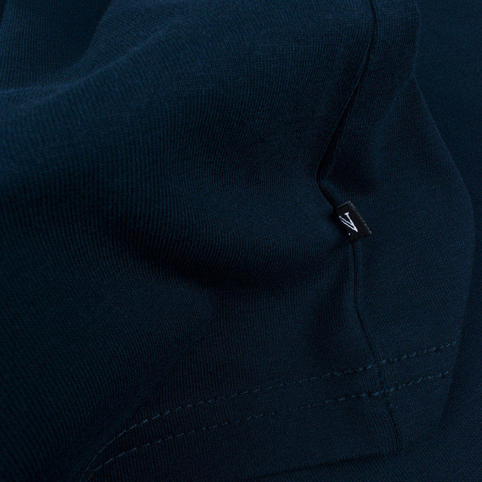 Detailled photo of a small label at the side of a navy blue t-shirt
