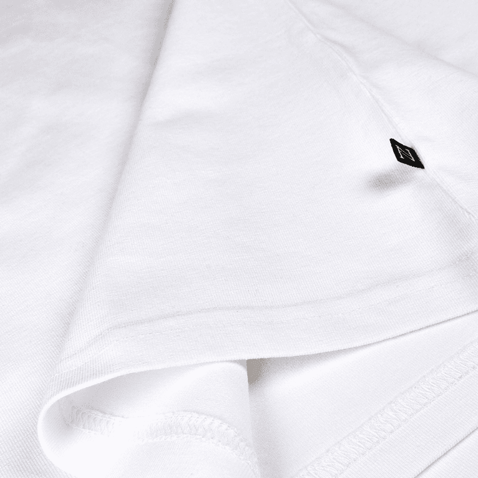 Seam of a white women's T-Shirt with a small black pip label