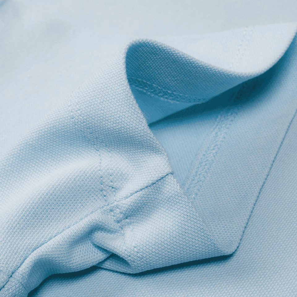 A detailled photograph of a light blue polo shirt showing the seam