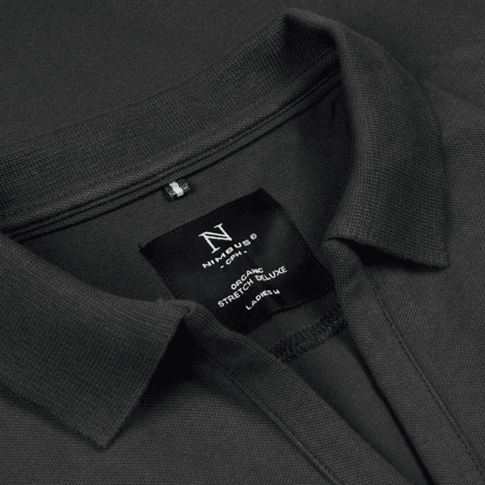 A detailled photograph of a black polo shirt showing the collar and the label inside the shirt