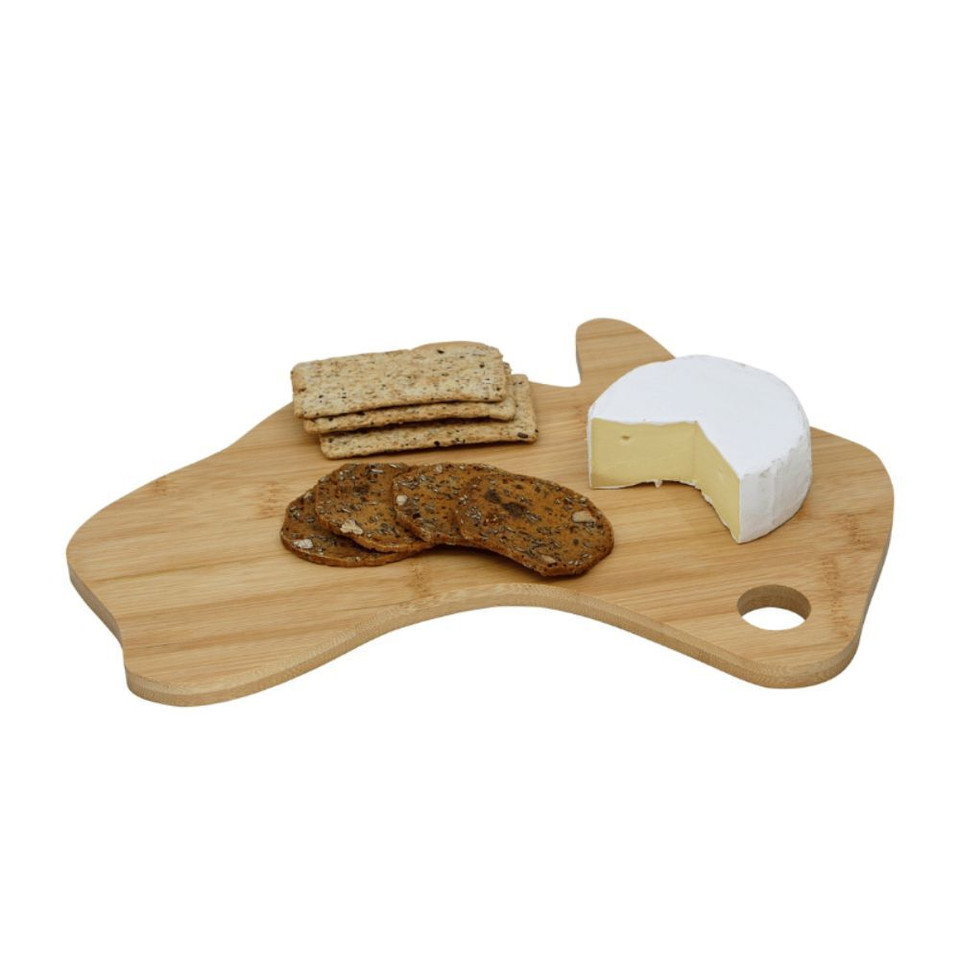 A bamboo cheese board in the shape of Australia with cheese, crackers, and cookies displayed on top.