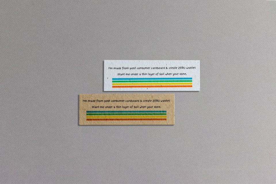 Two seed paper bookmarks in natural and brown shades, featuring vibrant stripes and branding.