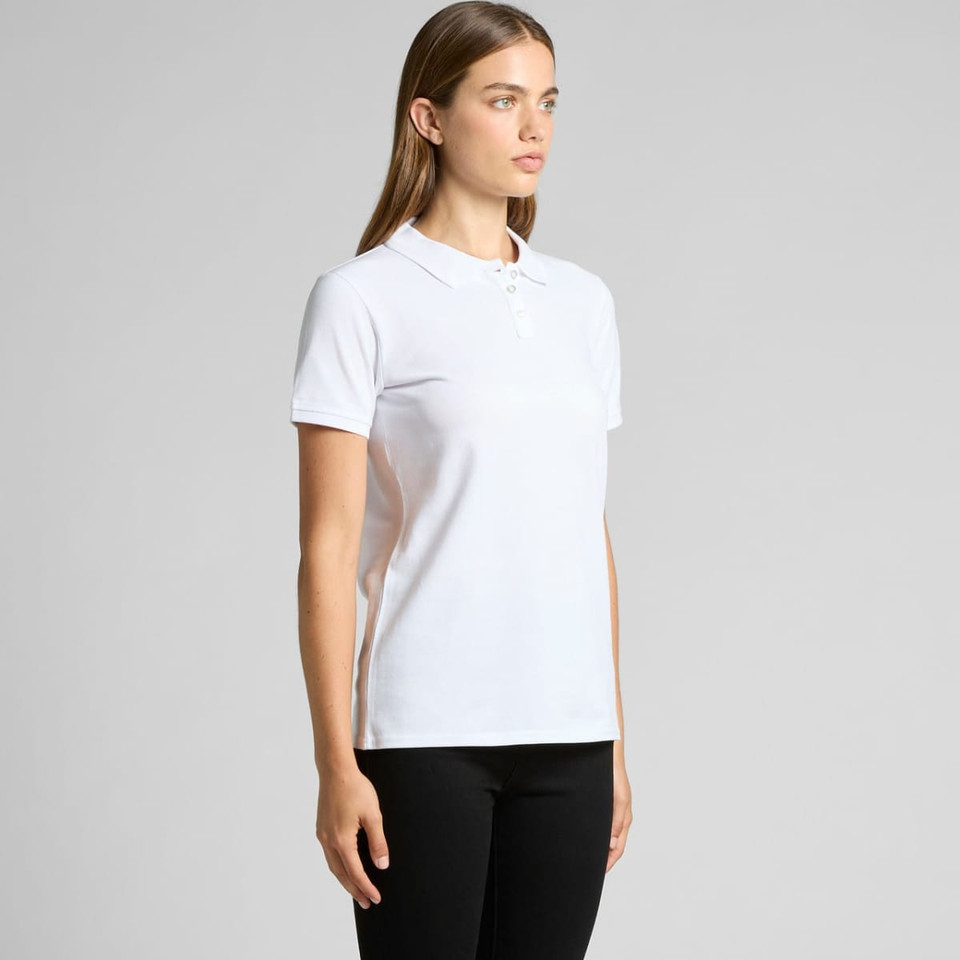 A white polo shirt with a collar and three buttons, featuring a small logo. The model stands facing to the side.