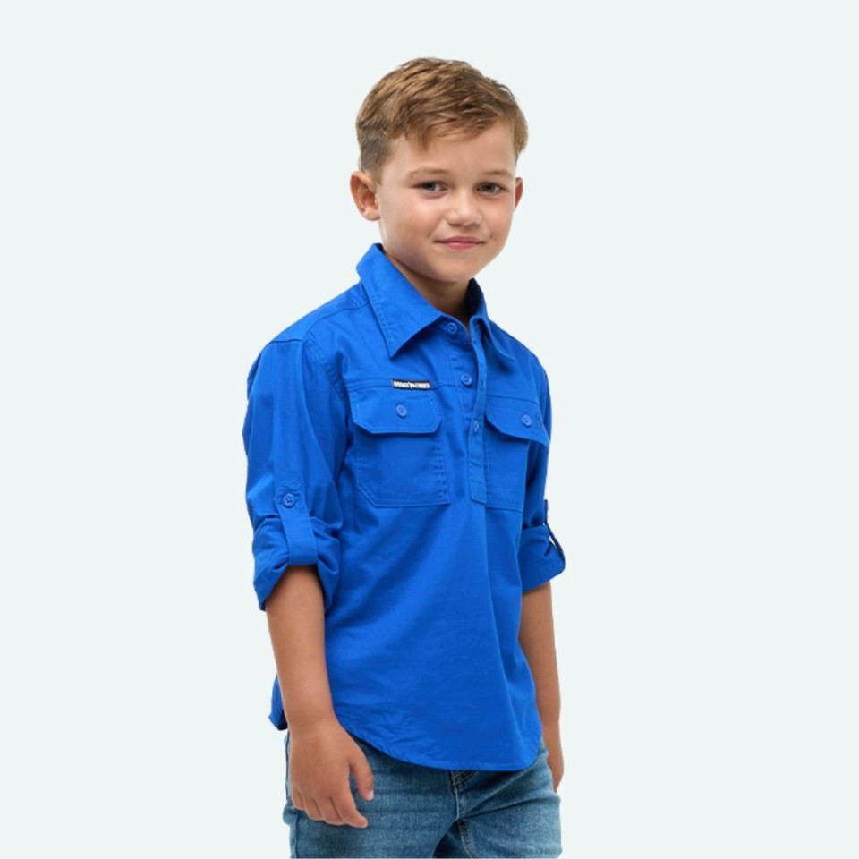 Angled front view of the Outback Cobber Hazeldean Kids Half Button Long Sleeve Work Shirt in royal blue, highlighting the half-button front, chest pockets, and rolled-up sleeve option.