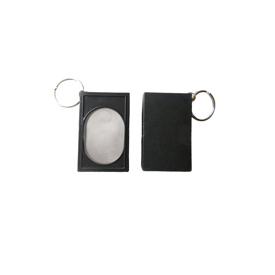 A black pet training clicker with a keychain attachment, featuring a smooth, oval button and a rectangular casing.