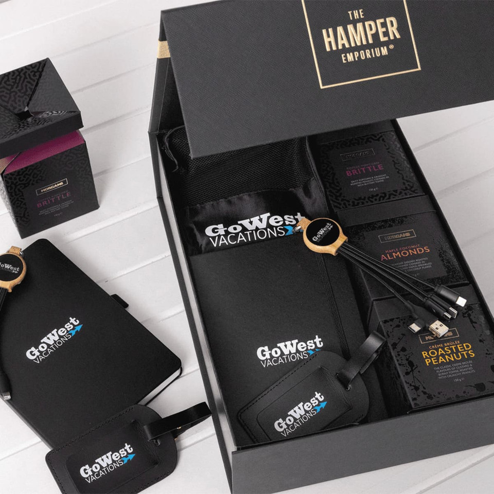 A custom travel kit featuring a black bag, snack packs, luggage tags, and a logo.