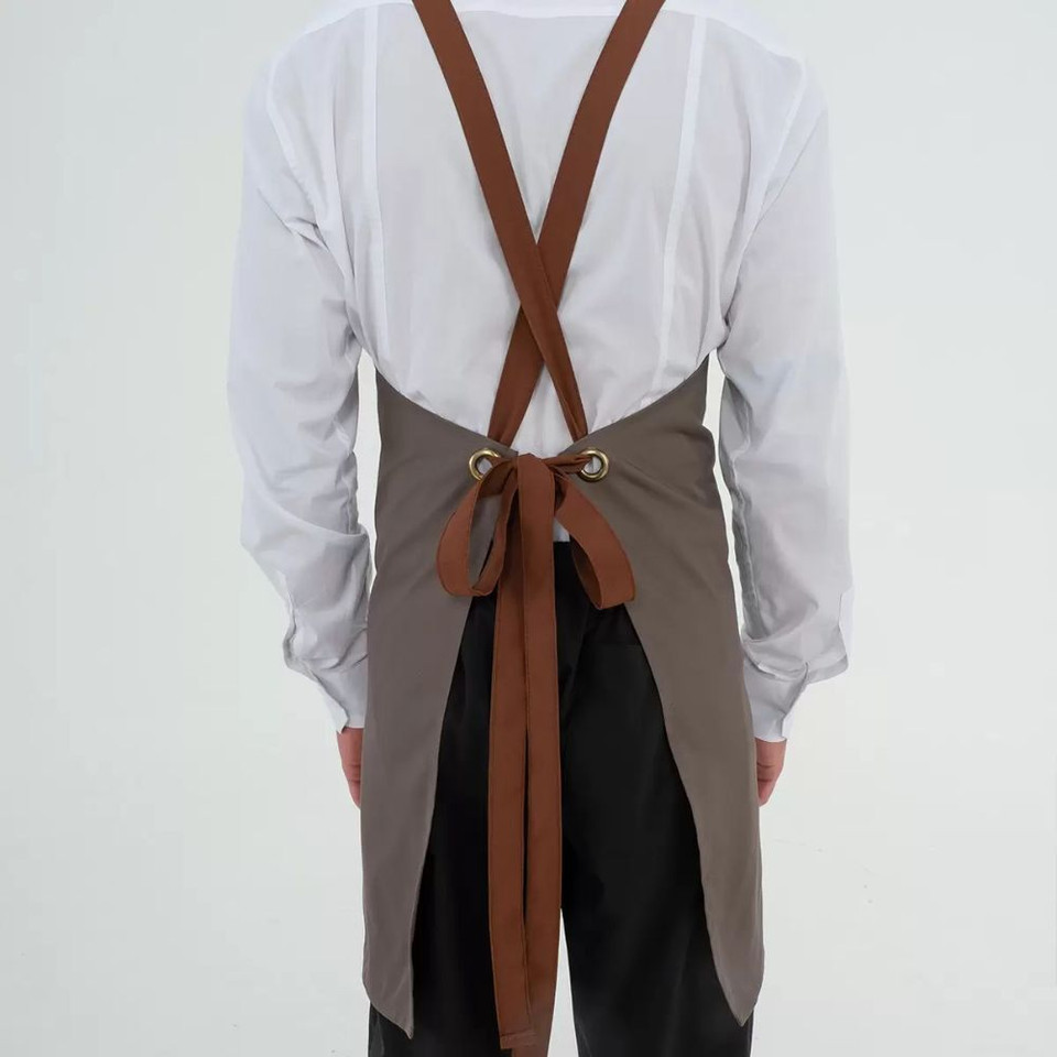 A grey apron with brown leather straps and multiple pockets, featuring a logo.