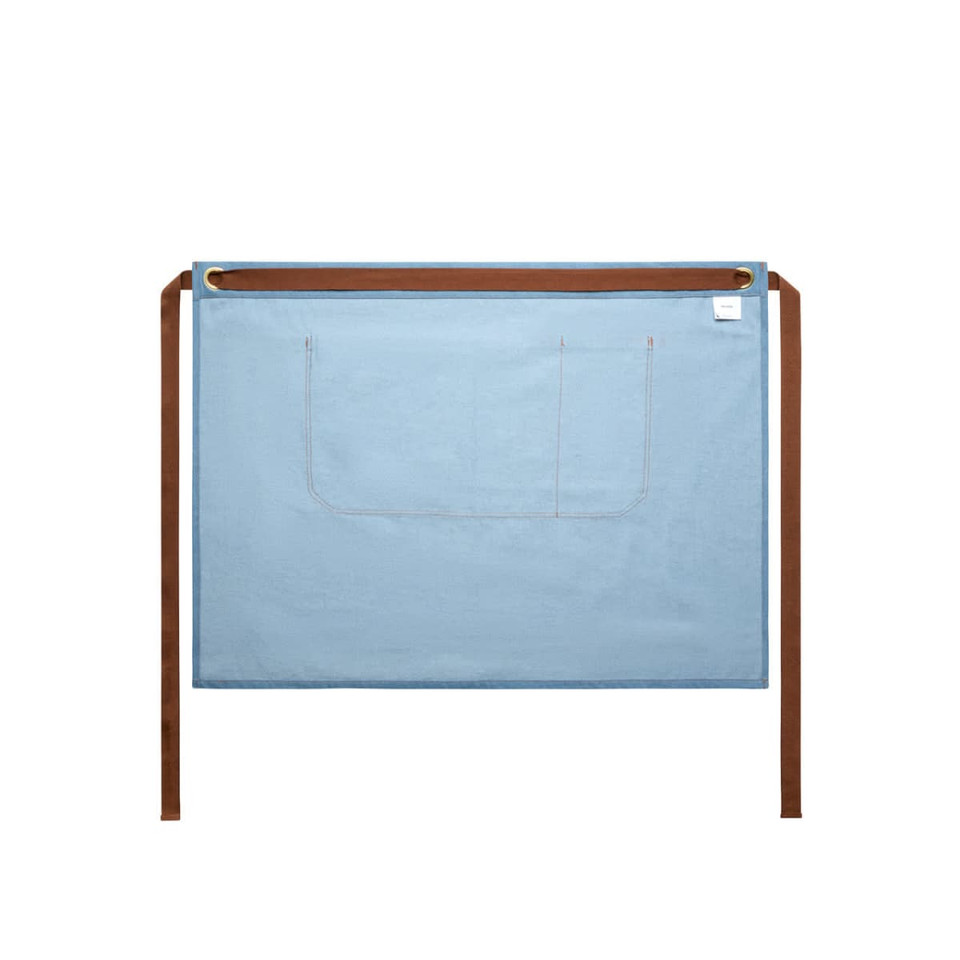 A denim half apron in blue with brown ties and a pocket, featuring a logo on the corner.