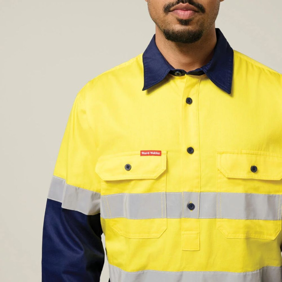 Man wearing an yellow and navy taped high-visibility work shirt.