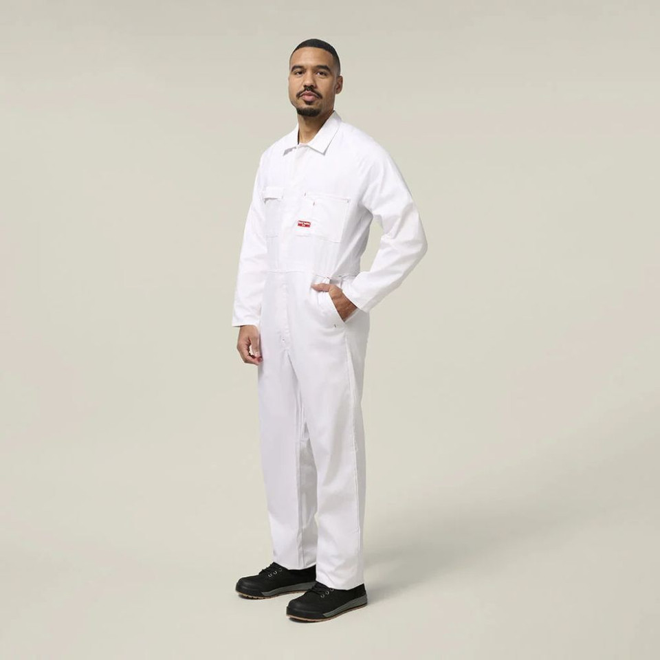 Side view of a male model wearing a white work jumpsuit and black work boots against a neutral background.