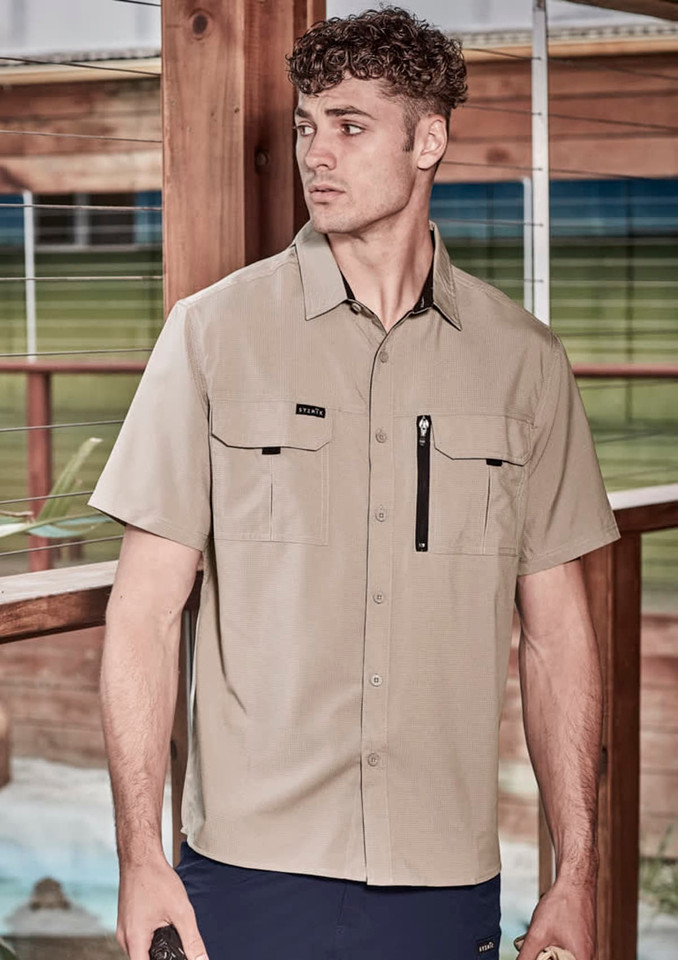 A light beige men's short sleeve button-up shirt with two chest pockets and a zipper pocket, featuring a logo.