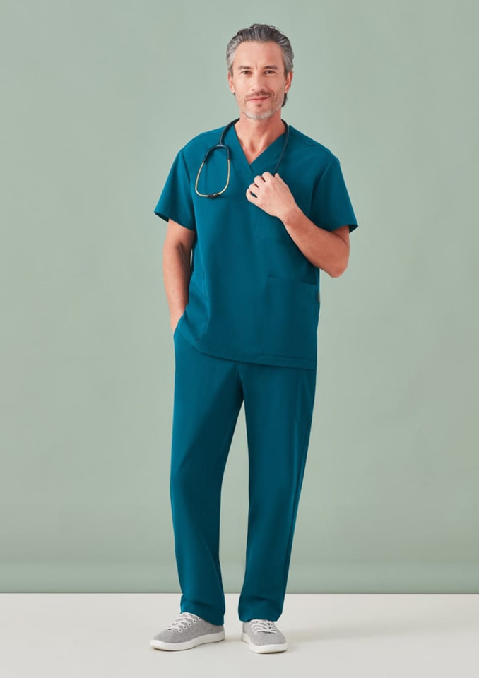 A unisex pulse v-neck scrub top in teal, paired with matching scrub pants, worn by a man with a stethoscope.
