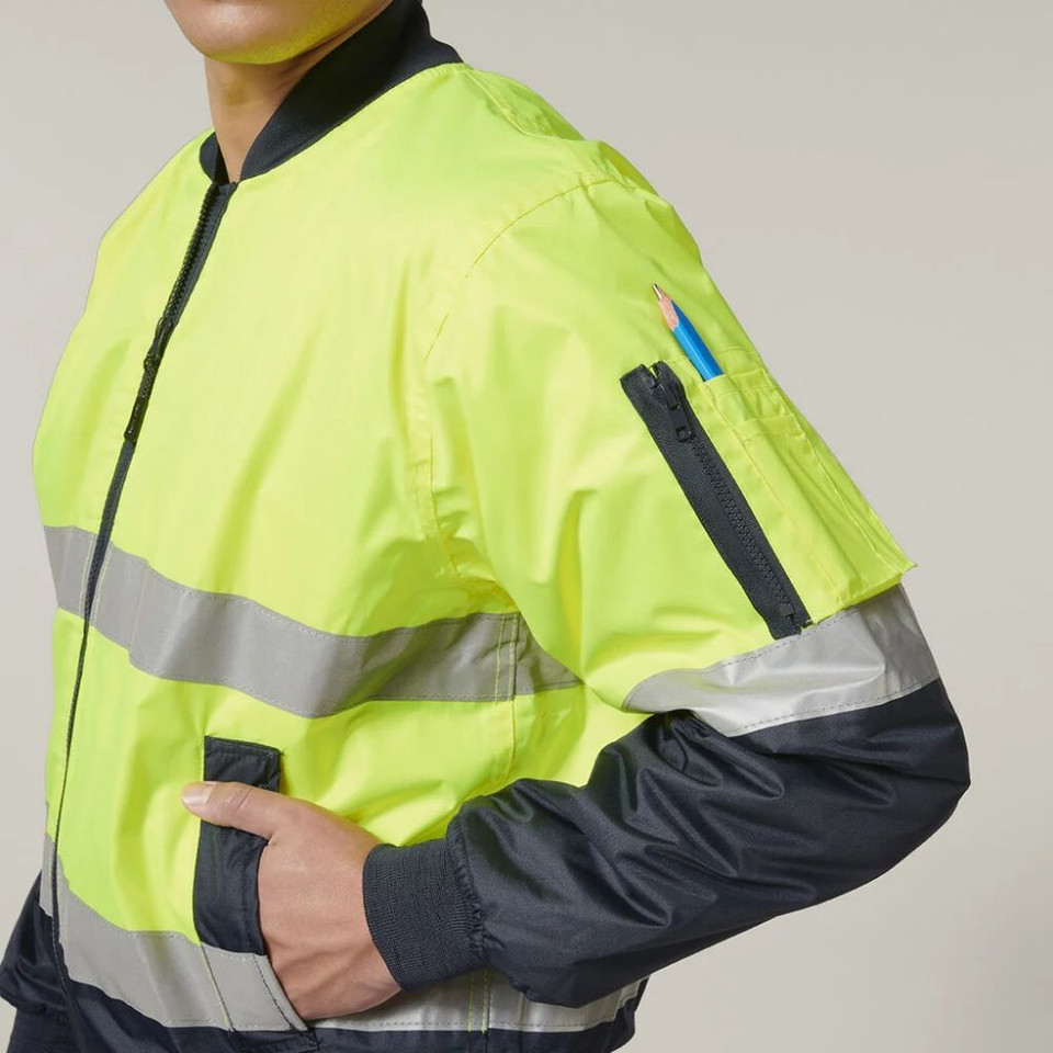 High-visibility safety jacket with reflective stripes, close-up of sleeve pocket.