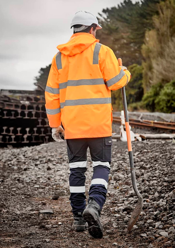 A high visibility orange and navy waterproof jacket with reflective stripes, worn by a person holding a shovel.