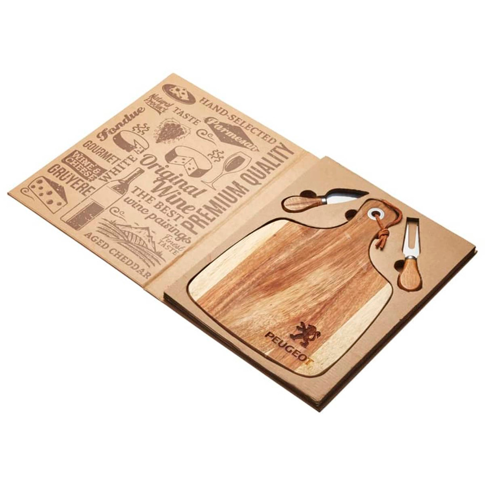A wooden acacia cheeseboard shaped like a paddle, accompanied by two cheese knives, presented in a cardboard box with branding.