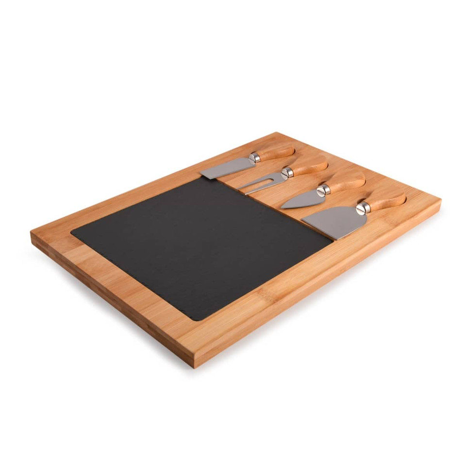 A bamboo cheese board with a black slate section and three stainless steel cheese knives.