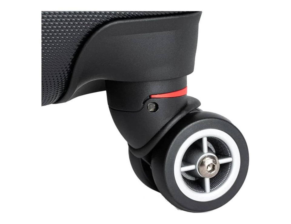 A close-up of a black wheeled suitcase wheel with a grey and white design, featuring a small red accent.