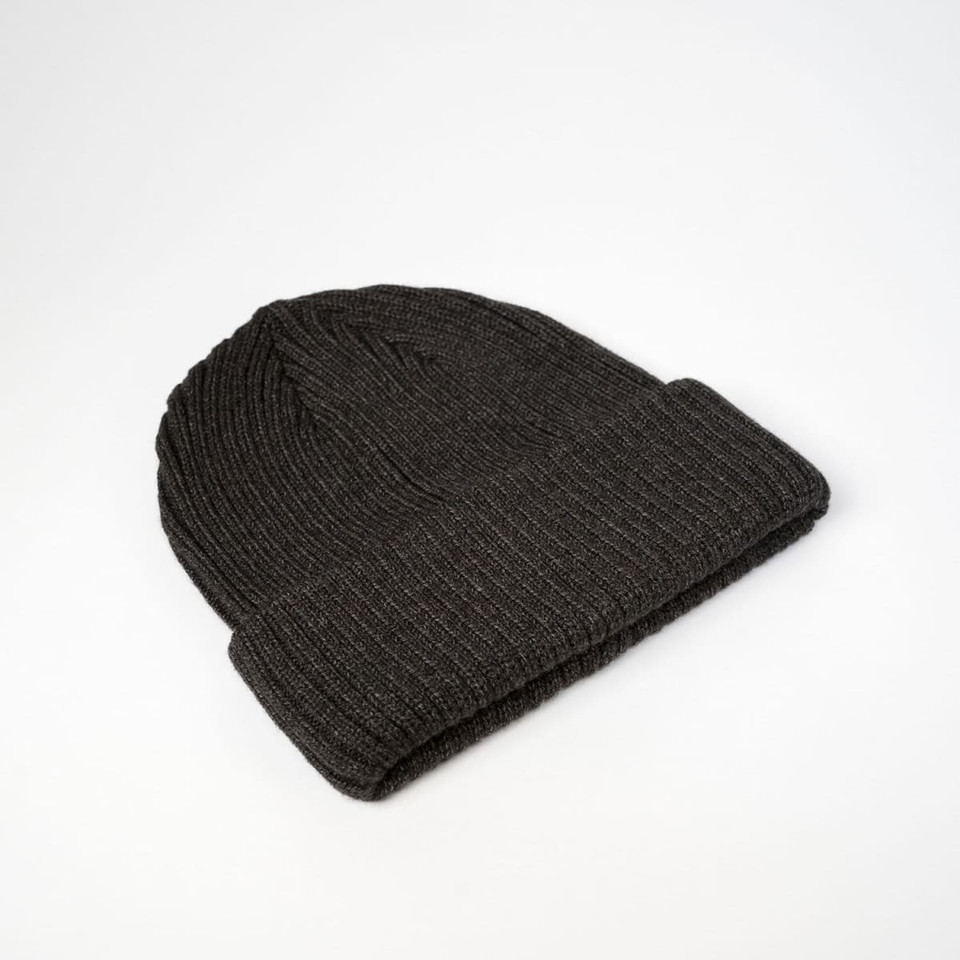 A dark grey ribbed beanie featuring a folded cuff and a logo.