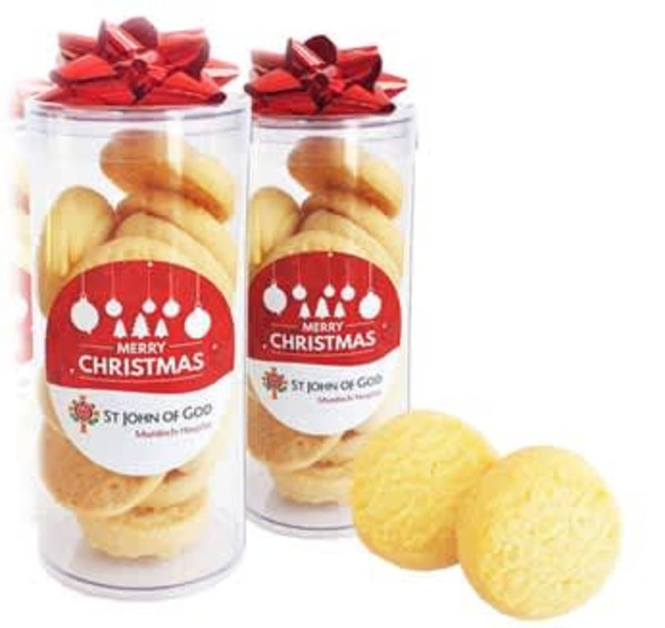 A transparent tube filled with traditional shortbread biscuits, featuring a red ribbon bow and festive decorations.