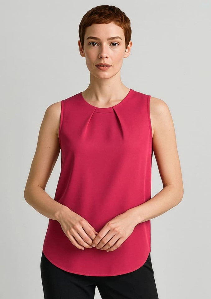 A sleeveless blouse in a vibrant pink with pleat detail. Model poses against a neutral background, wearing black trousers.