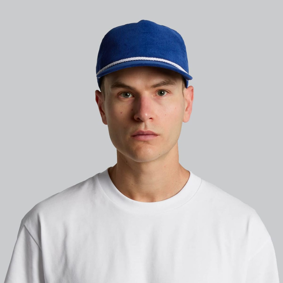 A blue cap with a white stripe, worn by a person in a plain white t-shirt. The cap also features a logo.