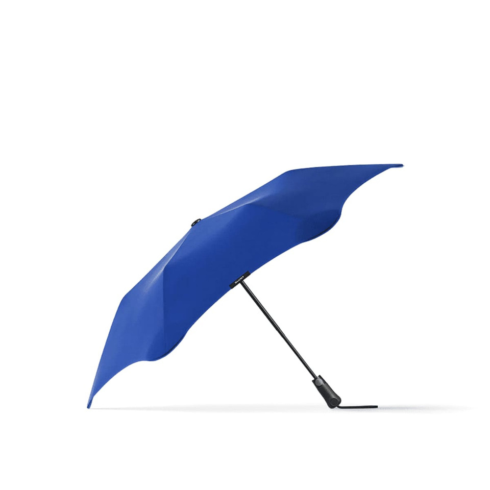 A blue BLUNT Metro Umbrella with a sleek design and a black handle, featuring a branding logo.