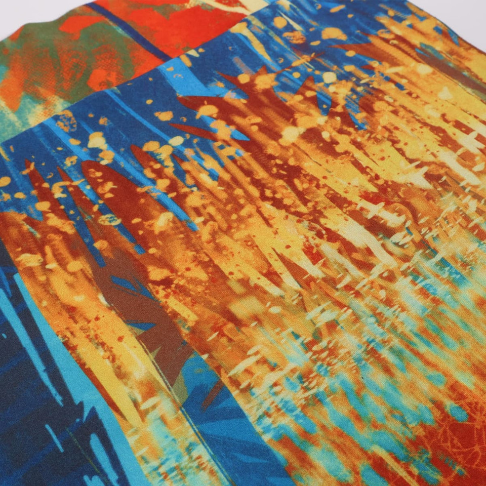 A vibrant, multicoloured fabric featuring shades of blue, orange, and yellow with an abstract design.